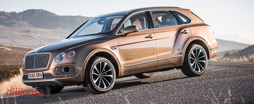 Bentley Bentayga на красивых дисках медленно катится с горки Коричневый Bentley Bentayga на литых дисках